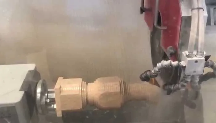 A CNC spindle with bronze tooling shaping stone through the water mist