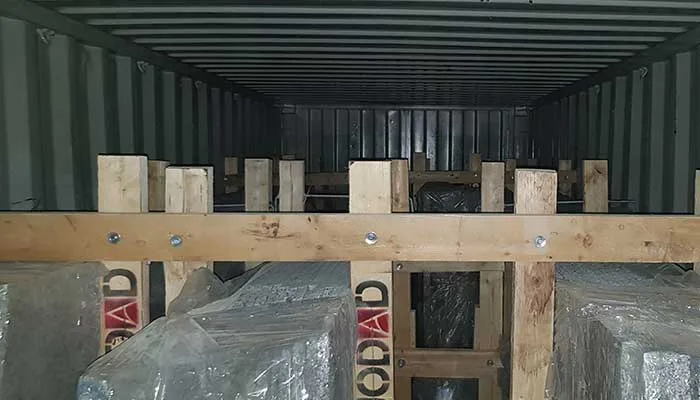 Jodad-branded bundles braced with timber inside a shipping container