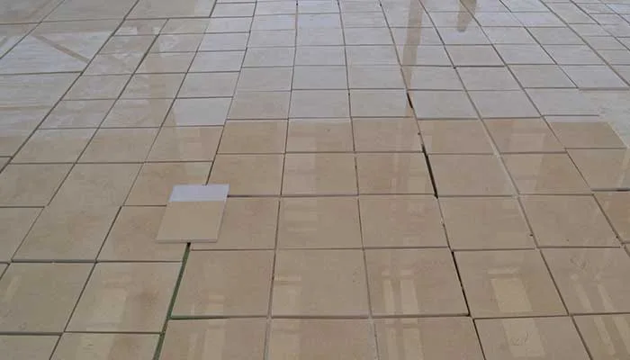 Finished beige tiles dry-laid in a grid on the floor for inspection