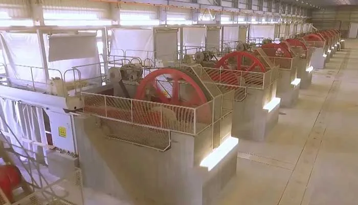 A row of gangsaw frames with red flywheels running down the marble hall