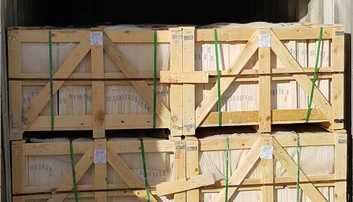 Labelled wooden crates strapped with green banding, stacked for export