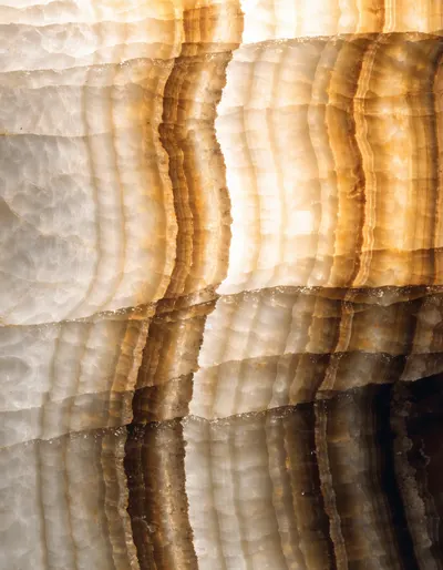 A polished slab of Egyptian honey alabaster, vein cut into straight translucent amber bands
