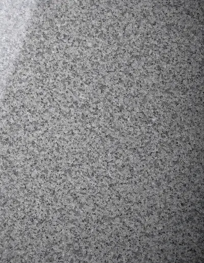 A polished slab of Karnak Grey granite, an even mid-grey with a fine, regular speckle