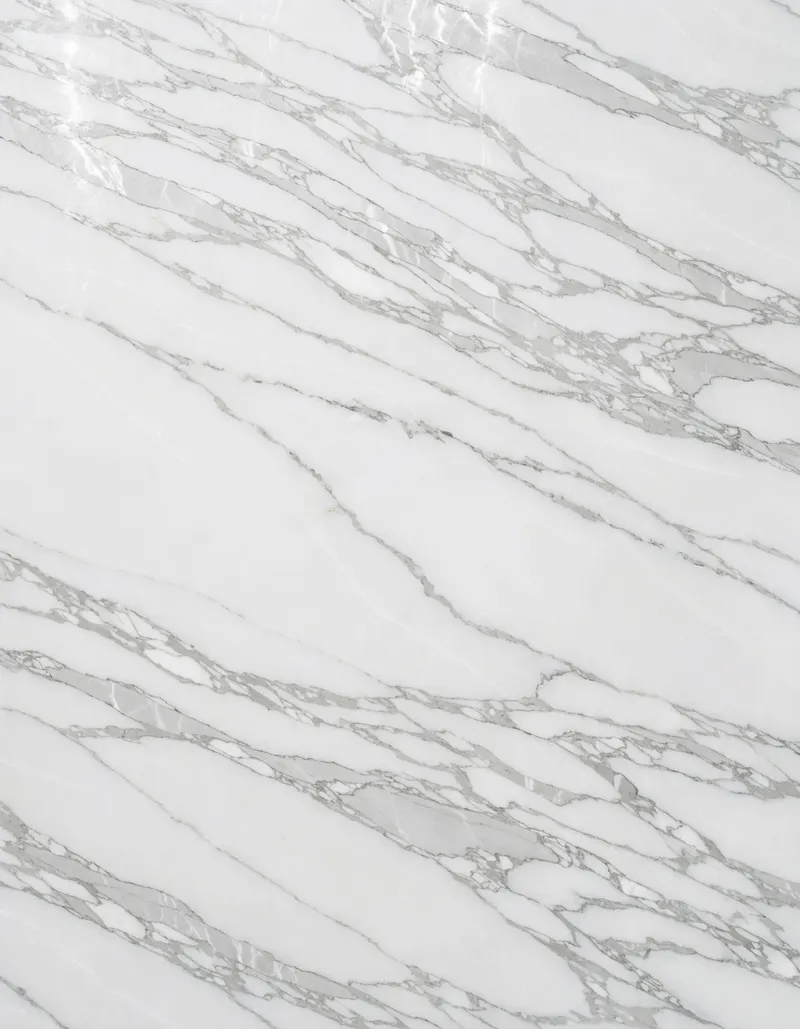 A polished slab of White Safaga marble, bright white with linear silver-grey veining